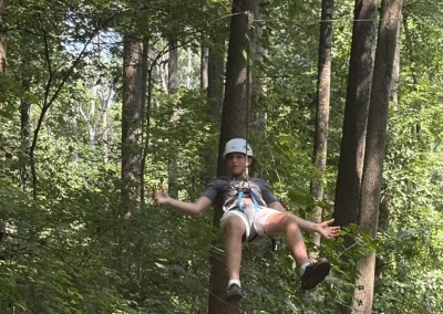 Teenager ziplining through the woods